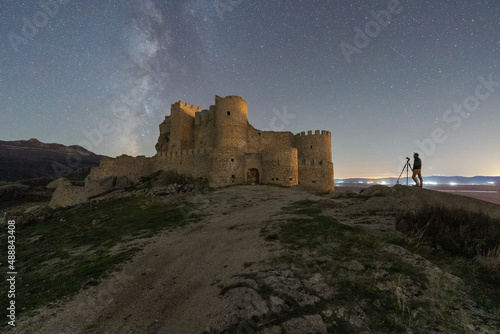 Person with camera near old castle at night time photo