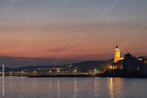 Evening seascape, sunset over the old town. Tourist center, the city of Sitges in Spain.