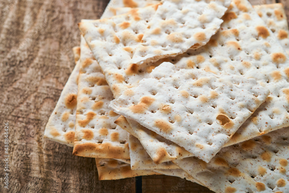 Matzah. Traditional ritual Jewish bread on old wooden rustic background. Passover food. Pesach Jewish holiday of Passover celebration concept.