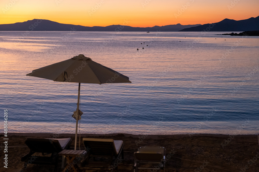 Wicker umbrella silhouette at Stoupa sandy beach at sunset. Mani Messenia, Greece Peloponnese.