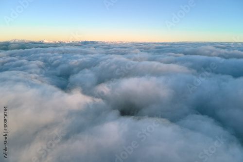 Aerial view from high altitude of earth covered with puffy rainy clouds forming before rainstorm