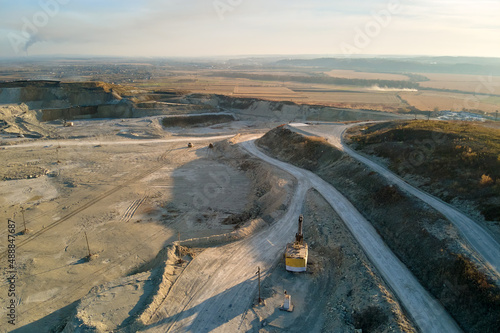 Aerial view of open pit mine of sandstone materials for construction industry with excavators and dump trucks. Heavy equipment in mining and production of useful minerals concept