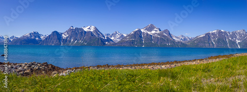 Panorama image of a landscape with the mountain range of the Lyngen Alps and the Lyngen fjord