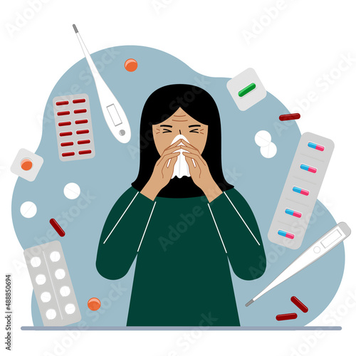 A Muslim woman covers his nose with his hands with a handkerchief. The concept of a cold person, seasonal allergies. Lots of medicines and thermometers.