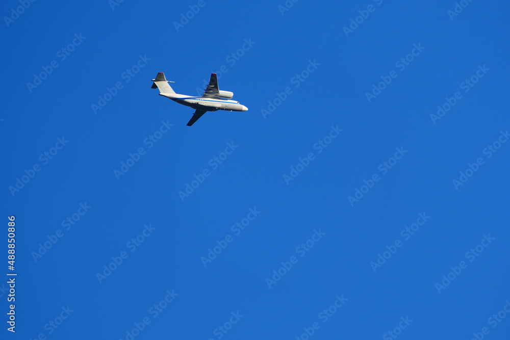 A passenger plane is flying in the sky. White passenger plane on a blue background. High quality photo