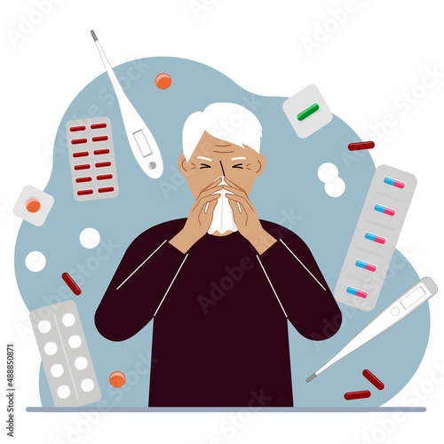 A grandfather covers his nose with his hands with a handkerchief. The concept of a cold person, seasonal allergies. Lots of medicines and thermometers.