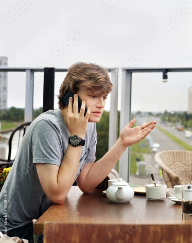 Lifestyle portrait of a young man using a smart phone outdoors
