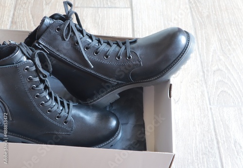 Beautiful women's black ankle boots with lacing in a box.