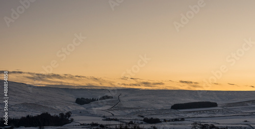 Late afternoon glow in the sky over the snow covered North Pennine landscape (Weardale, County Durham)
