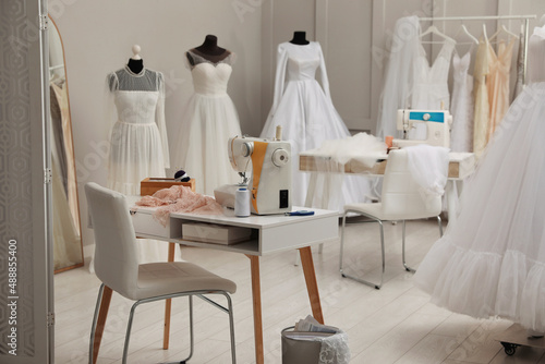 Dressmaking workshop interior with wedding dresses and equipment © New Africa