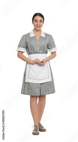 Full length portrait of young chambermaid in tidy uniform on white background