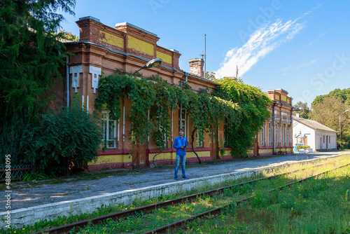 man or an adult guy is waiting on the platform of an old railway station. Background with copy space