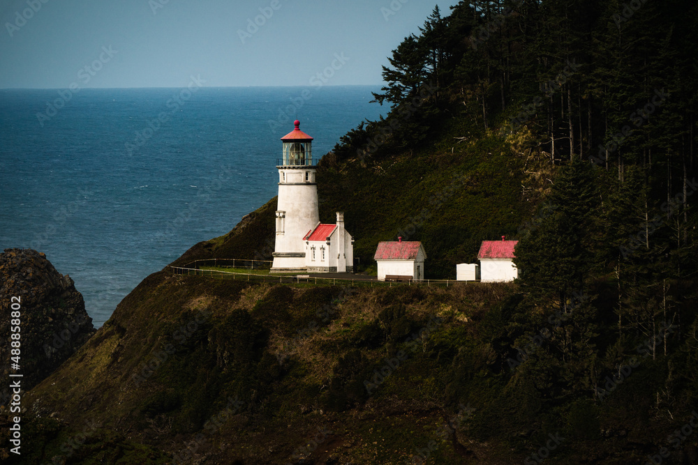 White and Red Lighthouse on the Oregon coast in Newport Oregon blue water ocean on a cliff