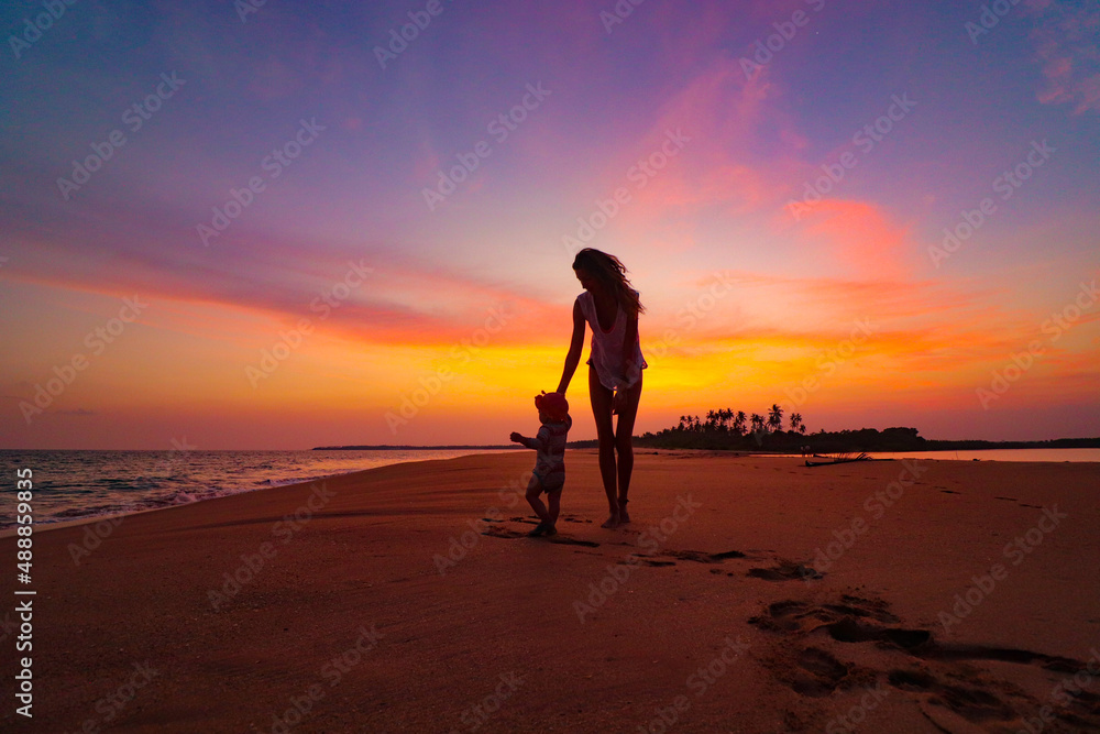 mother and child on the beach at the sunset in sri lanka