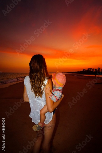 mother and child on the beach at the sunset in sri lanka