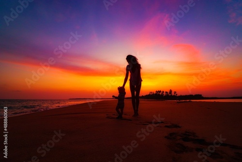 mother and child on the beach at the sunset in sri lanka