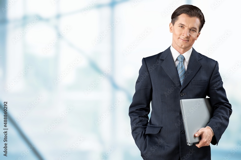 Smiling ceo businessman holding using cell phone mobile apps standing in office Smiling ceo businessman holding using cell phone mobile apps standing in office