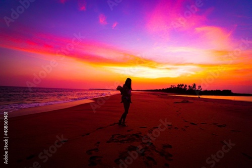 silhouette of person walking on the beach at sunset © Marius