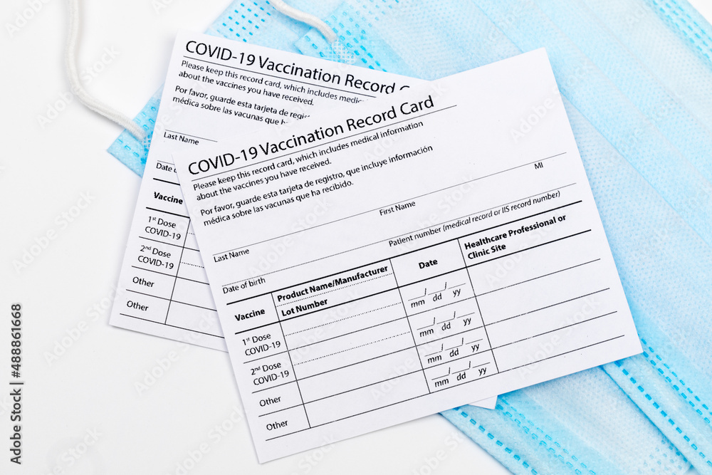 Fototapeta premium Coronavirus vaccination record card. Protective mask divided into two parts. Concept of defeating Covid-19 - Image