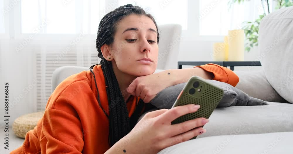 Tired woman using mobile phone in living room at home Tired woman using mobile phone in living room at home