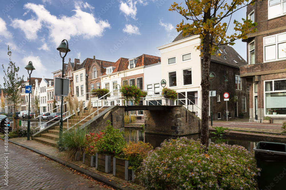 Small bridge over the canal with flower pots and canal houses in the center of the city of Gouda