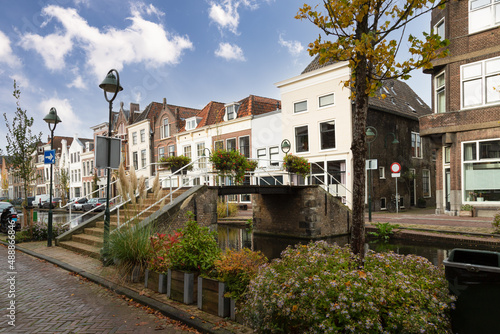 Small bridge over the canal with flower pots and canal houses in the center of the city of Gouda © Jan van der Wolf