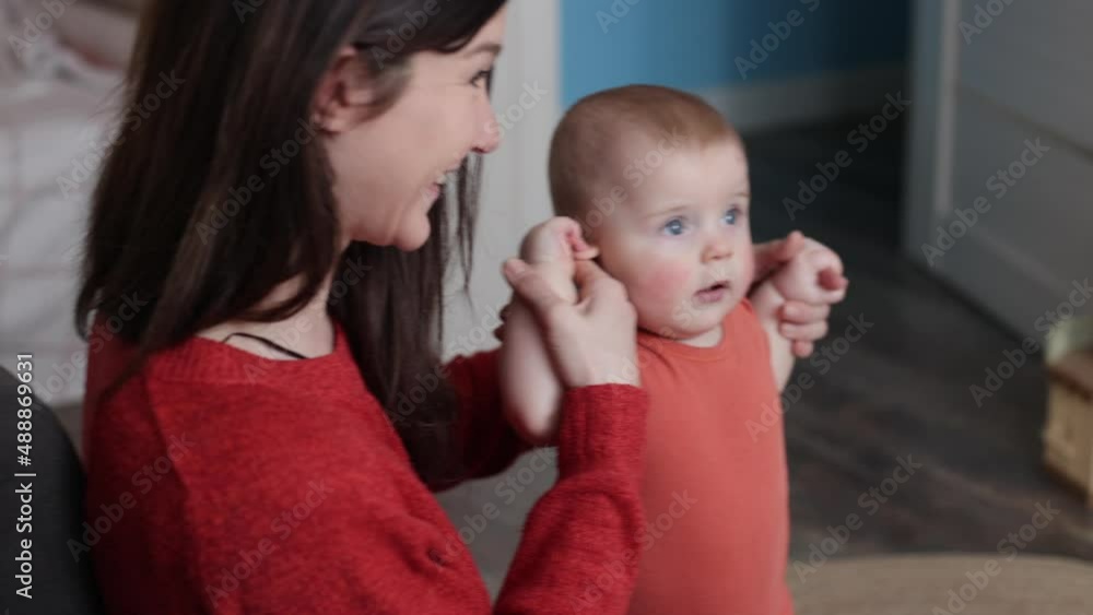 Young cheerful woman playing with her infant bay. Mother spending time with her baby. Motherhood Young cheerful woman playing with her infant bay. Mother spending time with her baby. Motherhood