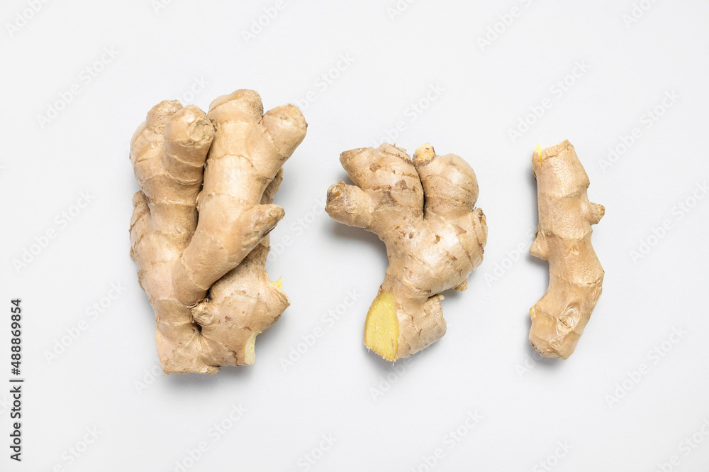 Fresh ginger root on light gray background top view flat lay. Spice for cooking, herbal tea with ginger to boost immunity. Natural organic ginger for health, medicine, protection against colds Fresh ginger root on light gray background top view flat lay. Spice for cooking, herbal tea with ginger to boost immunity. Natural organic ginger for health, medicine, protection against colds