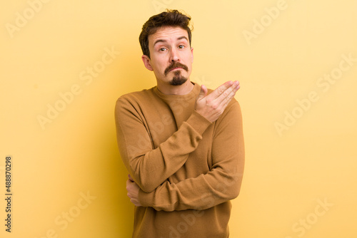 Billede på lærred young hispanic man feeling confused and clueless, wondering about a doubtful exp
