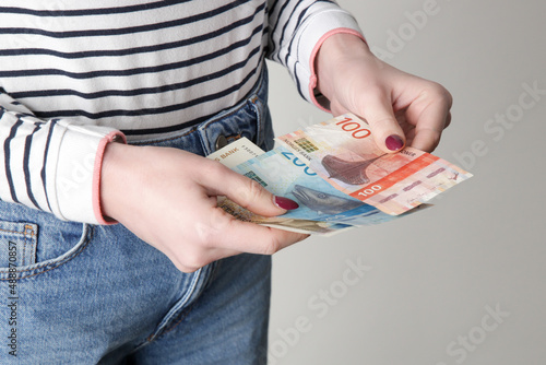 Woman holding Norwegian krone banknotes