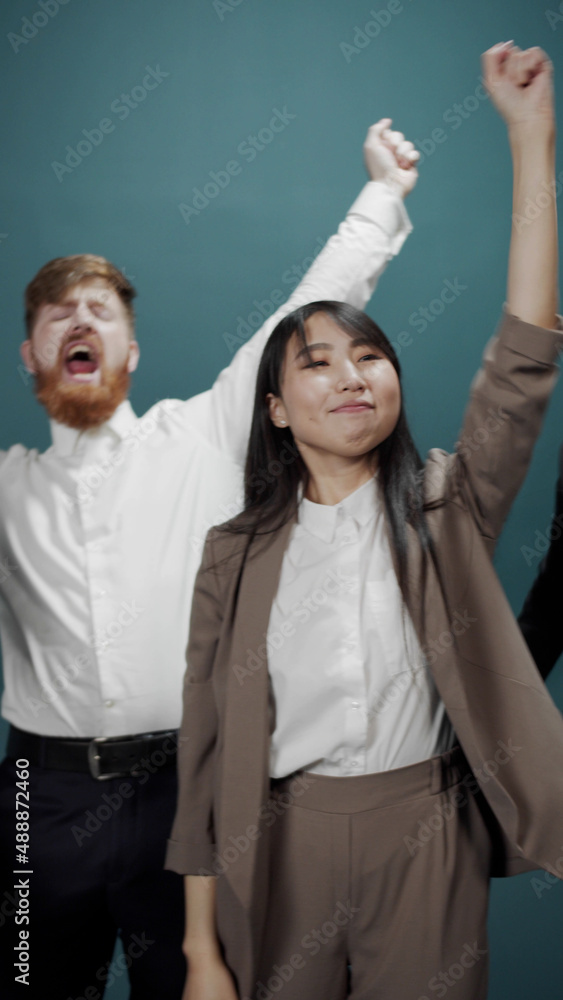 Group of young business people hugging each other and smiling while standing in the room Group of young business people hugging each other and smiling while standing in the room