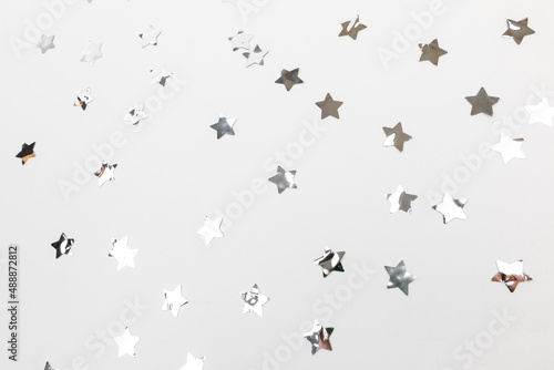 star silver confetti on white background flat lay text place .
