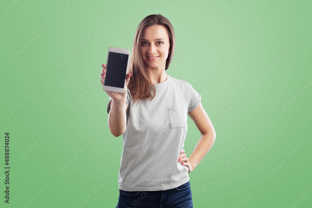 Young woman laughing while pointing at her cellphone Young woman laughing while pointing at her cellphone