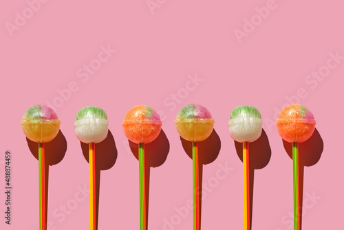 Colorful Set of Lollipops. pattern made with caramel on a stick on bright pink background.  creative pattern.