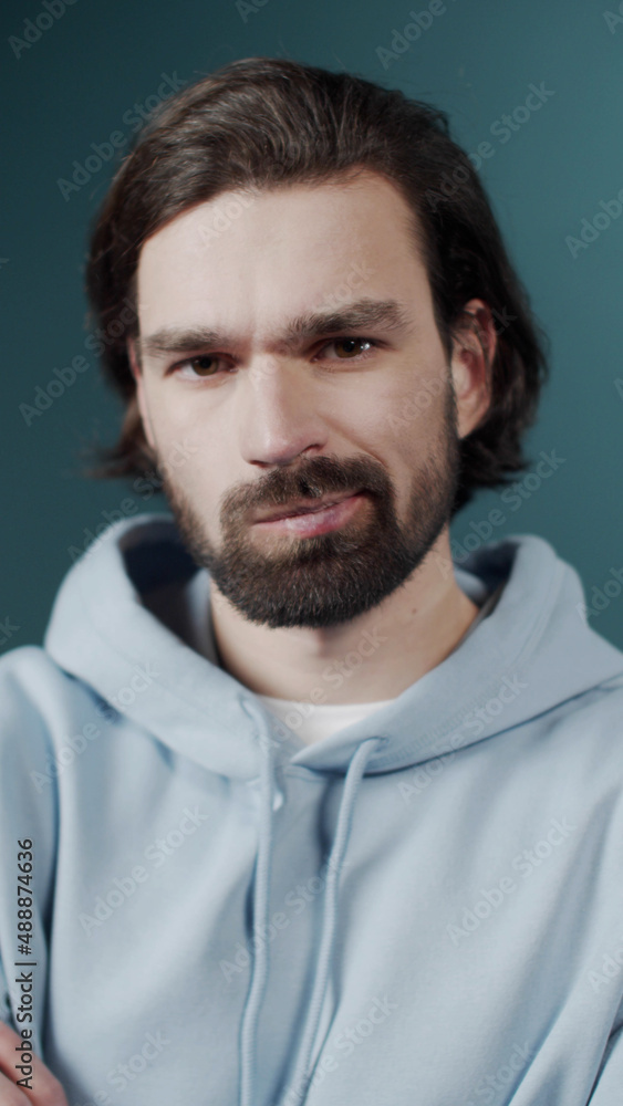 Isolated Dark-haired guy confused feels doubt while makes choice, dressed in casual hoodie Isolated Dark-haired guy confused feels doubt while makes choice, dressed in casual hoodie