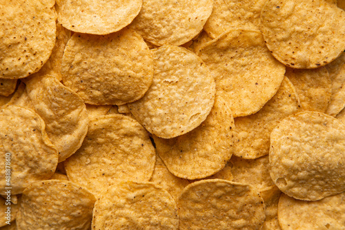 A closeup image of freshly baked and salted yellow corn tortilla chips.