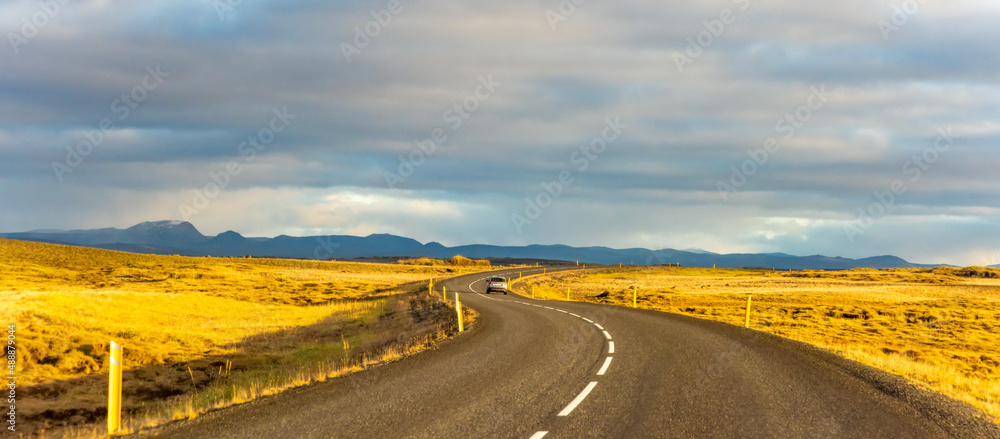 Iceland road landscape with clouds and emply field