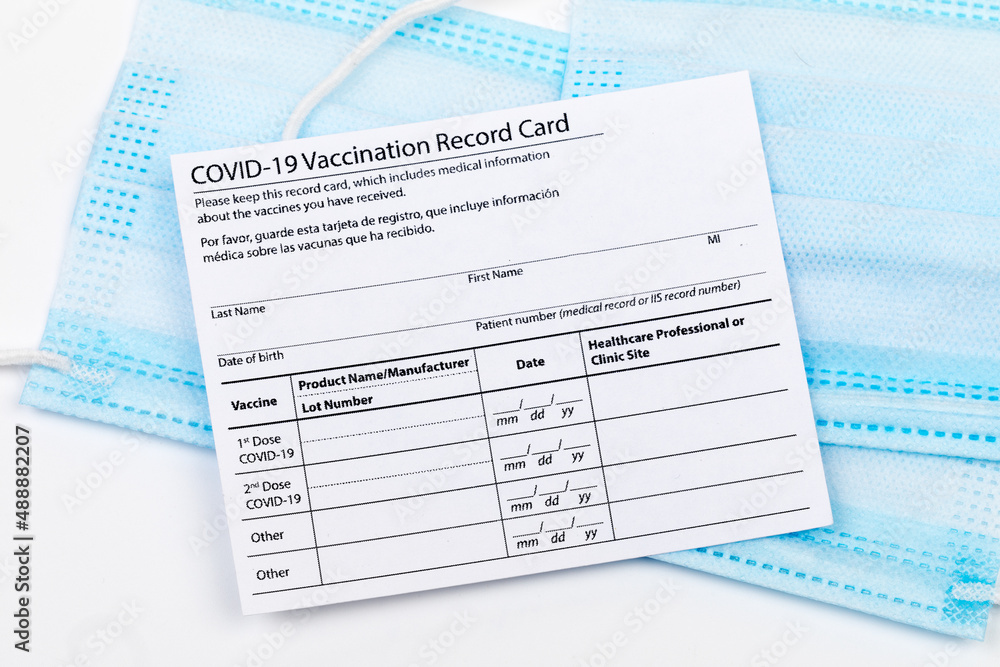 Obraz premium Coronavirus vaccination record card. Protective mask divided into two parts. Concept of defeating Covid-19 - Image