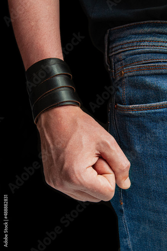 Man's hand with a clenched fist on a dark background. Fist threat for fighting, aggressive and angry stance. Domestic violence concept.