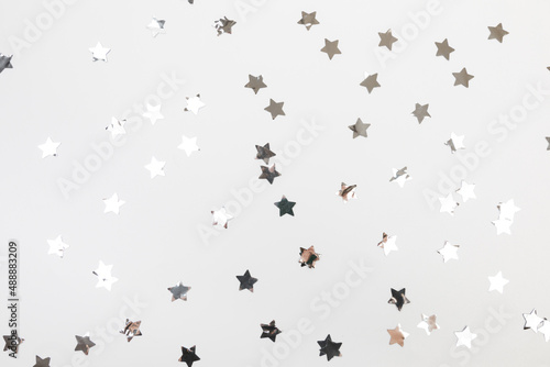 star silver confetti on white background flat lay text place .