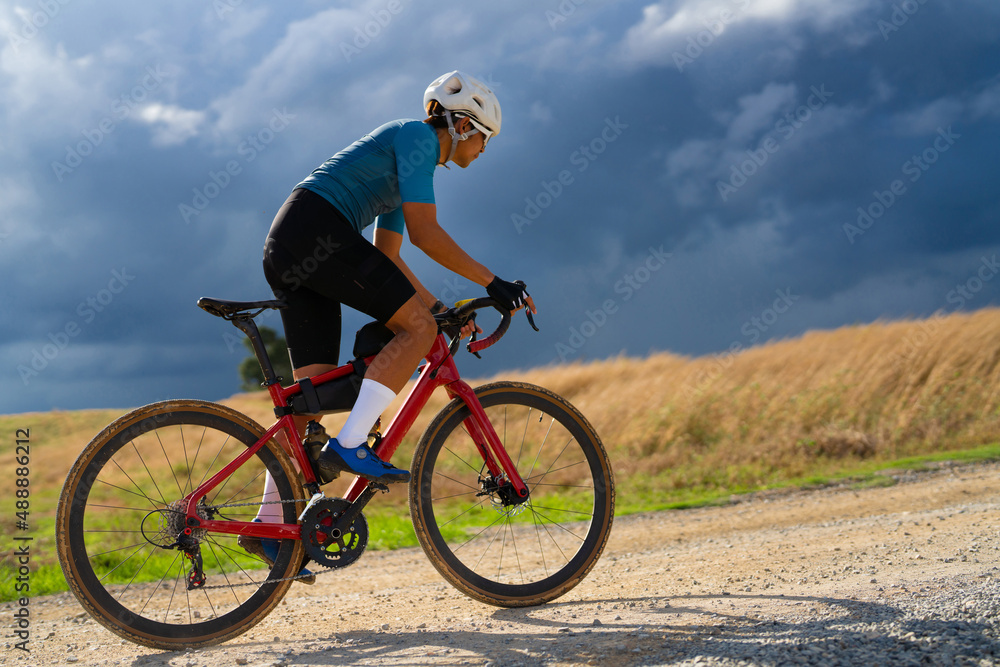 Cyclists practicing on gravel roads in bad weather day Cyclists practicing on gravel roads in bad weather day