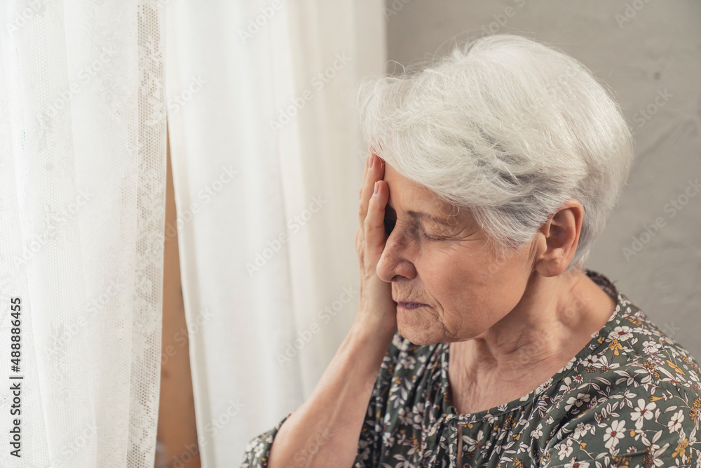 heartbroken granny suffering from dementia touching her face with one palm medium close up shot . High quality photo heartbroken granny suffering from dementia touching her face with one palm medium close up shot . High quality photo