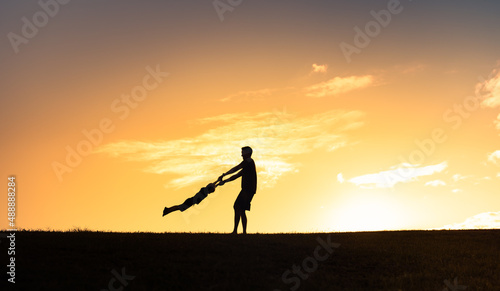 Father spinning his child in the air having fun playing in the park 