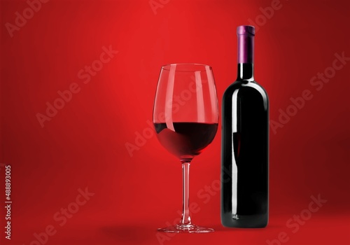 Red wine glass over colored background on the desk