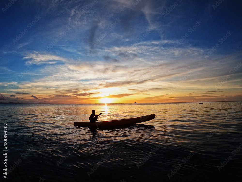 Silhouette of young men on Kayak