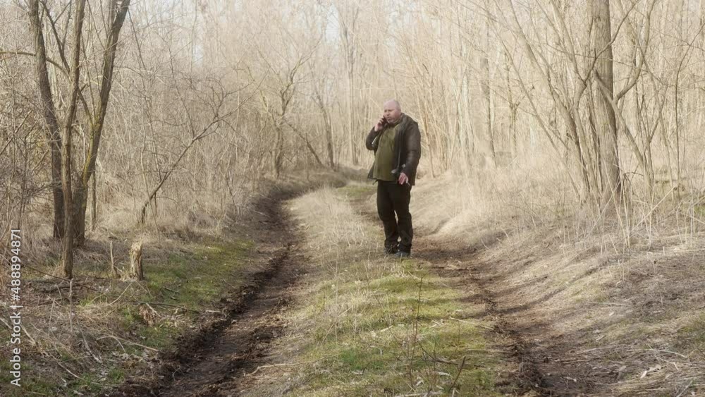 a man arguing with someone on a mobile phone in the forest a man arguing with someone on a mobile phone in the forest