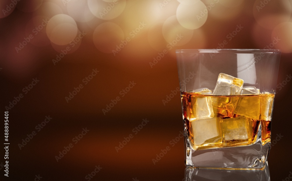 Glasses of alcohol stand on desk of cognac in wine cellar illuminated by soft light Glasses of alcohol stand on desk of cognac in wine cellar illuminated by soft light