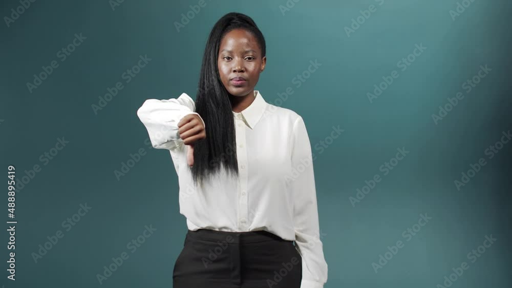 A sadness african woman is standing and showing thumbs down A sadness african woman is standing and showing thumbs down
