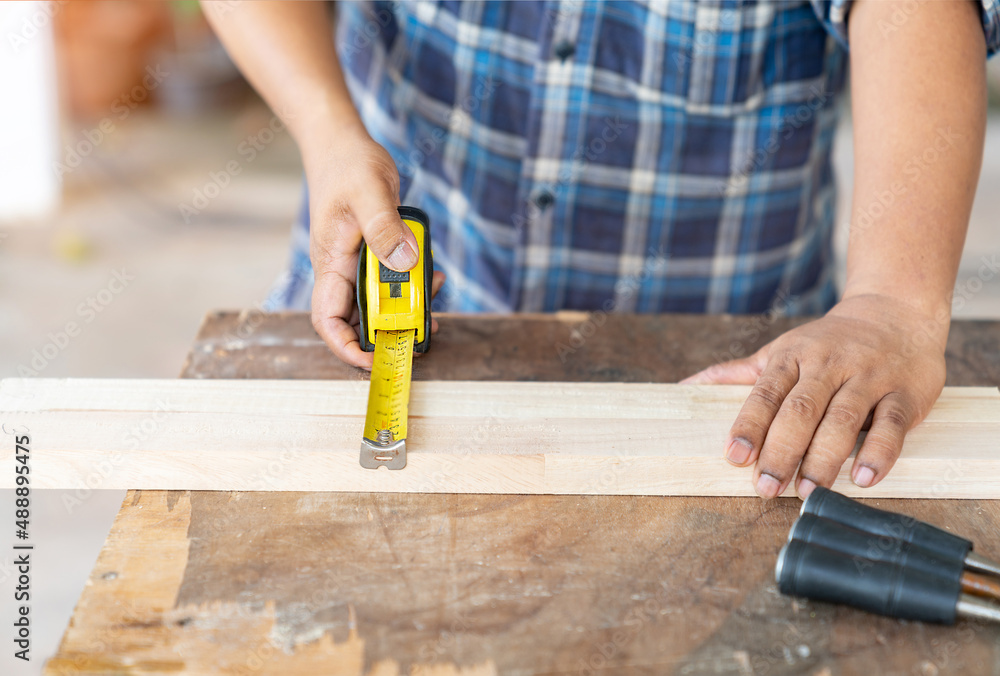 Carpenter Measuring a Wooden Frame for build furniture