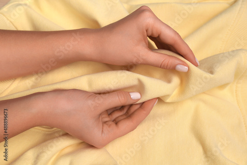 Woman touching soft yellow fabric  closeup view